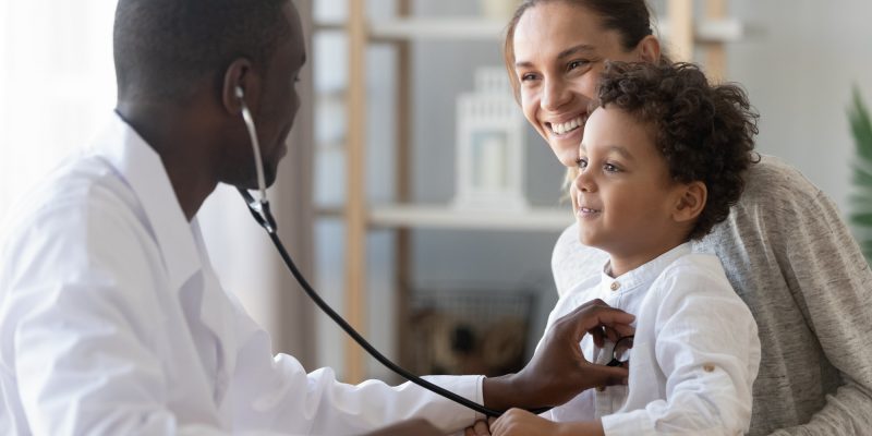 African male pediatrician hold stethoscope exam child boy patient visit doctor with mother, black paediatrician check heart lungs of kid do pediatric checkup in hospital children medical care concept